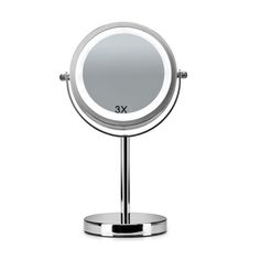 a round mirror sitting on top of a metal stand