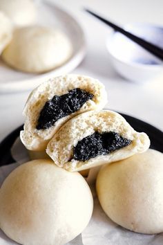 three small pastries on a plate with spoons next to it and another one in the background