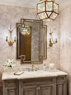 a bathroom vanity with two sinks and a large mirror on the wall above it, along with a chandelier