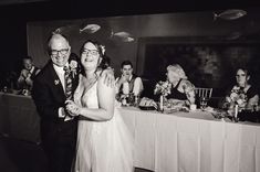 a bride and groom dance together in front of their guests at a wedding reception with fish on the wall behind them