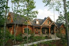 a house in the woods with lots of windows and stone steps leading up to it