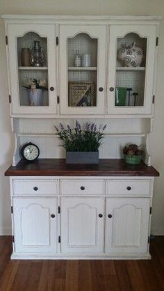 a white china cabinet sitting on top of a hard wood floor