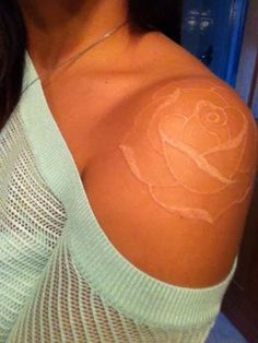 a woman with a rose tattoo on her shoulder