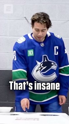 a man standing in front of a table with an ice hockey jersey on and the caption that reads, that's insane