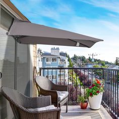 a balcony with two chairs and an umbrella over the patio area, overlooking a street