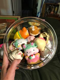 a glass bowl filled with lots of small toy animals