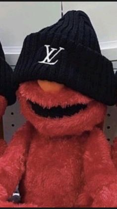 a red stuffed animal wearing a black hat