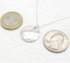 "This lightweight small sterling silver disc necklace was handmade by me. I used my small size (3/4 inch diameter) of silver disk and hammered it to give it a reflective, shiny, and attractive surface that just glows. It is comfortable and especially pretty with its sterling cable chain. The sterling silver has a great shine, and is a small 3/4\" diameter (19 mm). The necklace in the picture has an 18\" (45.7 cm) sterling silver cable chain, and other sizes are available during checkout for a hi Silver Hammered Coin Necklace As Gift, Hammered Silver Coin Necklace In Sterling Silver, Silver Sterling Coin Necklace With Round Disc, Round Sterling Silver Hammered Coin Necklace, Hammered Sterling Silver Coin Necklace, Hammered Round Sterling Silver Coin Necklace, Silver Hammered Round Coin Necklace, Silver Hammered Coin Necklace, Simple Sterling Silver Round Disc Necklace