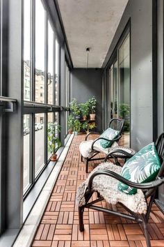 an empty balcony with chairs and potted plants