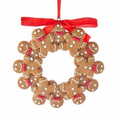 a gingerbread wreath ornament hanging from a red ribbon on a white background