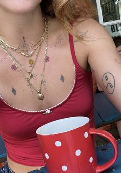 a woman sitting at a table with a red coffee mug