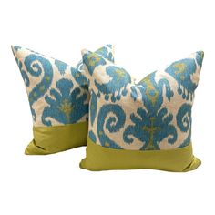 two blue and green pillows sitting next to each other