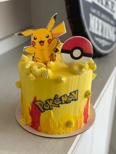 a pokemon cake with yellow frosting and pikachu figurines on top