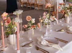 a table set with flowers and candles for a formal dinner or function at a wedding