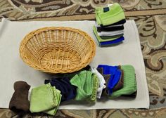 a wicker basket sitting on top of a rug next to folded towels and socks