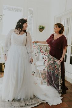 two women standing next to each other in a room