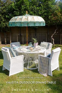 an outdoor dining table with chairs and umbrella