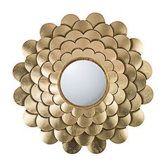 a mirror that is sitting on top of a white surface with gold circles around it