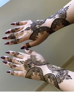 two hands with henna tattoos on them