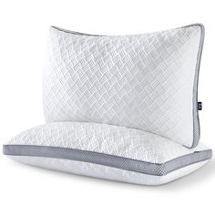 two pillows on top of each other with white and gray trimmings, one in the