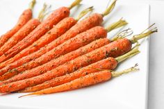 a bunch of carrots that are on a white plate