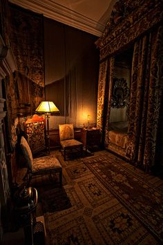 a bed room with a neatly made bed next to a chair and a lamp on a table