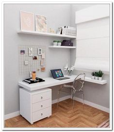 a white desk with a laptop computer on top of it next to a shelf filled with pictures