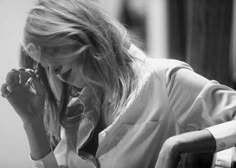 black and white photograph of a woman talking on the phone while sitting in a chair