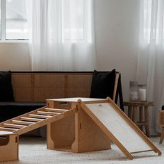 a living room filled with furniture and a slide in front of a couch next to a window