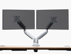 two computer monitors are sitting on top of a desk with one monitor facing the other