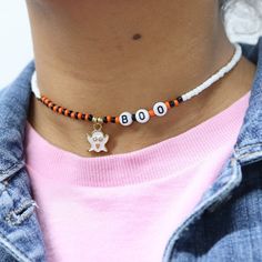 a close up of a person wearing a beaded necklace with an animal on it