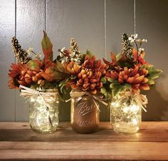 three mason jars filled with flowers on top of a wooden table next to a sign that says, all that's rustic match your fall decor