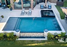 an aerial view of a house with a pool in the yard and patio furniture around it