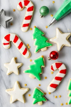 christmas cookies decorated with icing and candy canes on a white marble countertop