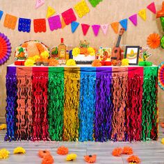 a colorful party with streamers and tassels on the table, decorations around it