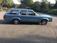 a blue station wagon parked in a parking lot