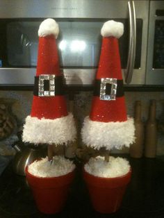 two red buckets filled with white rice and santa hats sitting on top of a counter