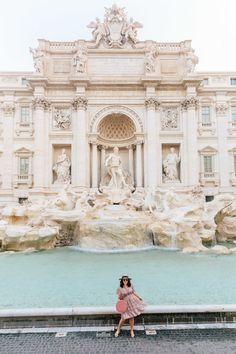 a woman standing in front of a fountain