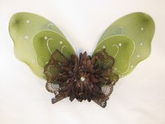 a green and brown butterfly decoration on a white background