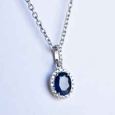 "Dark Royal Blue Sapphire is surrounded by tiny diamonds in a scattered halo. This pendant is a perfect gift idea. * Main Gemstone : Natural Untreated Blue Sapphire * Halo : Natural White Diamonds * Blue Sapphire : 6 x 8 mm ; 1.50 cts (Approx) * Diamond Weight : 0.20 cts * Color - Clarity Grade : H-I, Vs-Si (Halo) * Gold Weight Pendant - 1.2 gms. 14k Solid White Gold (Approx) Your purchase will arrive inside a lovely gift box. If you like this pendant, please press \"Pin it\" button on the right Oval Pendant Necklaces With Halo Design As Gift, Gift Necklaces With Oval Pendant And Halo Design, Oval Pendant Necklace With Halo Setting As Gift, Oval Pendant Necklace With Halo Setting, Oval Halo Setting Necklace As Gift, Oval Necklace With Halo Setting As Gift, Oval Halo Setting Necklace For Gift, Oval Sapphire Necklace With Halo Setting, Sapphire Necklaces With Halo Setting