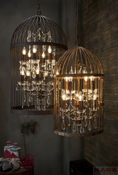 two birdcages with lights hanging from them