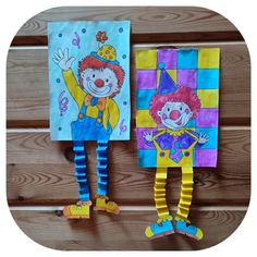 two colorful clowns are hanging on the wall