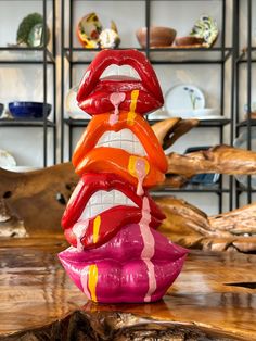 a stack of fake lips sitting on top of a wooden table in front of shelves