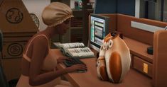 a woman sitting at a computer desk with a cat pillow on it's lap