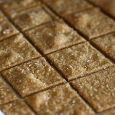 square pieces of food sitting on top of a white tablecloth covered in brown sugar