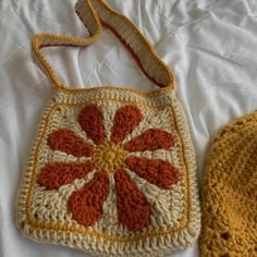 two crocheted purses sitting on top of a white bed next to each other