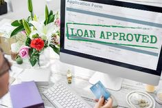 a man sitting in front of a computer with the word loan approved on it