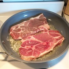 two pieces of raw meat in a frying pan