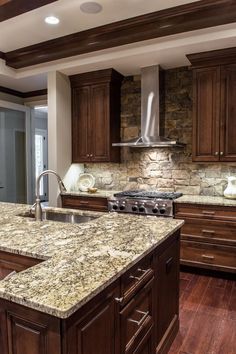 a large kitchen with granite counter tops and wooden cabinets, along with an island in the middle