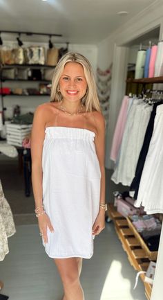 a woman standing in front of a clothing rack